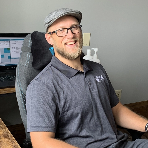 Chiropractor Baldwin WI Jacob Stoffel Dr. Jacob Stoffel sitting in an office chair at The Forge Chiropractic office.