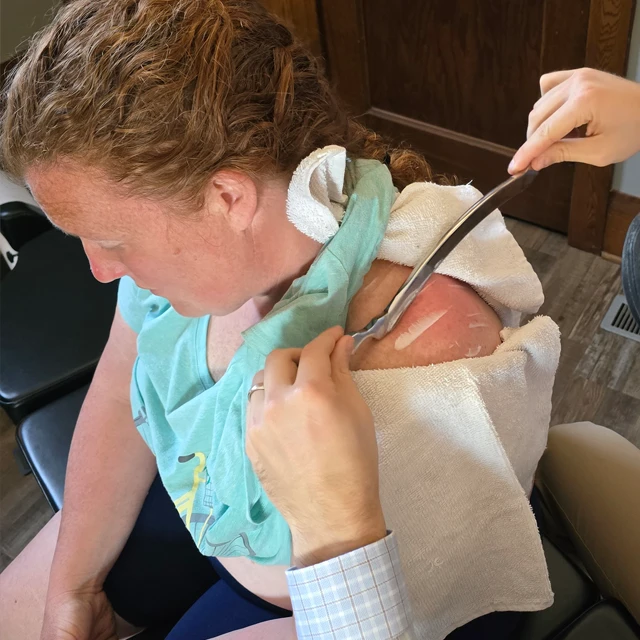 Dr. Jacob Stoffel uses a metal tool to perform the Graston Technique on a patient's shoulder