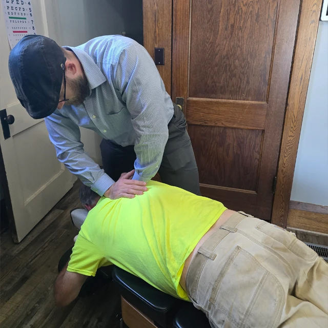 Chiropractor Jacob Stoffel adjusting the upper back of a patient