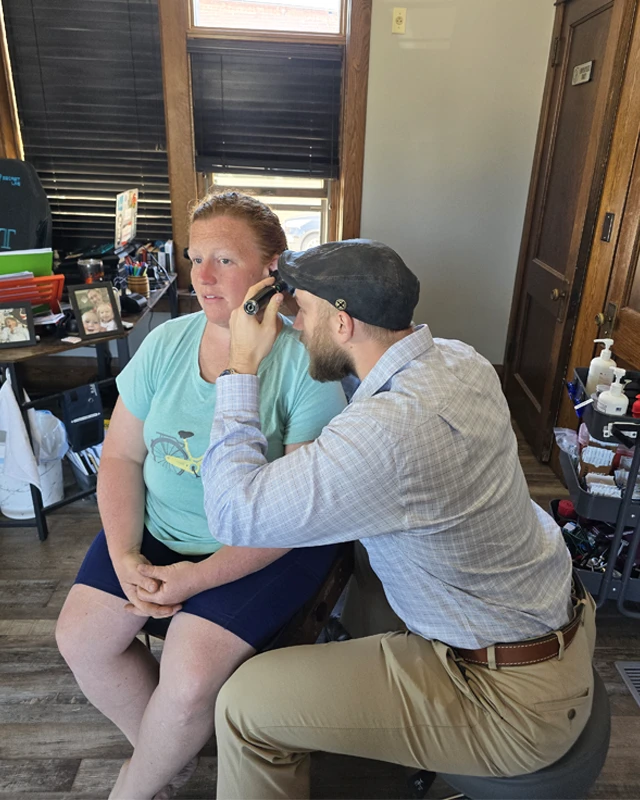 Chiropractor Jacob Stoffel examining a DOT patients ear with an otoscope