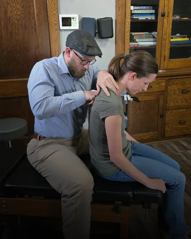 Chiropractor Jacob Stoffel examining a back pain patient